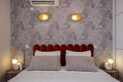 a bedroom with a bed with two lights on the wall at Phaedrus Living: Glyfada Seaview Luxury Penthouse in Athens