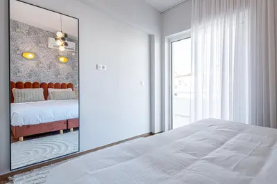 a white bedroom with a mirror and a bed at Phaedrus Living: Glyfada Seaview Luxury Penthouse in Athens