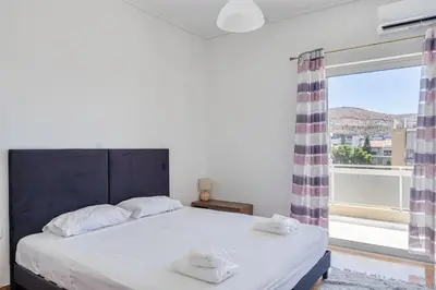 a bedroom with a bed and a large window at Charming 2 Bdrm Glyfada Getaway in Athens