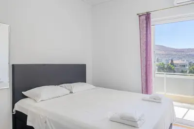 a bedroom with a white bed with a large window at Charming 2 Bdrm Glyfada Getaway in Athens