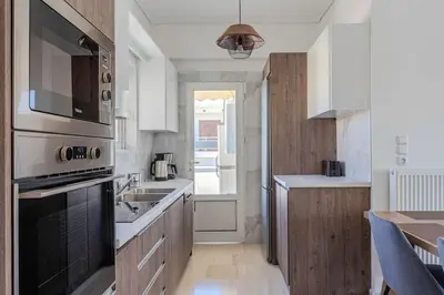 a kitchen with a sink and a stove top oven at Charming 2 Bdrm Glyfada Getaway in Athens