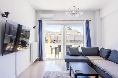 a living room with a couch and a large window at Charming 2 Bdrm Glyfada Getaway in Athens