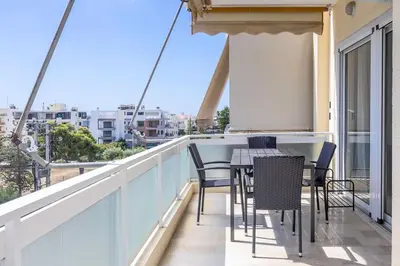 a balcony with chairs and a table on a building at Charming 2 Bdrm Glyfada Getaway in Athens