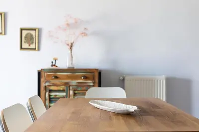 a wooden table with two white plates on top of it at Stratum Apartment by LobbySquare in Athens