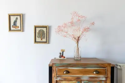 a vase of flowers on top of a dresser at Stratum Apartment by LobbySquare in Athens