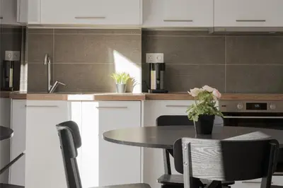 a kitchen with white cabinets and a table with chairs at Acropolis Urban Life in Athens