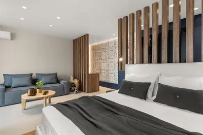 a bedroom with a large bed and a couch at ACRON 12 penthouse Acropolis suites in Athens
