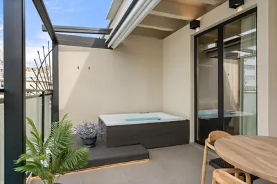 a balcony with a bath tub and a table at ACRON 12 penthouse Acropolis suites in Athens