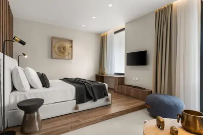 a bedroom with a bed and a tv and a chair at ACRON 12 penthouse Acropolis suites in Athens