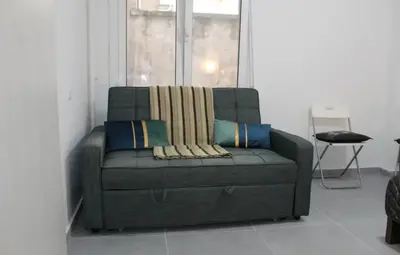a green couch in a room with a window at Cozy apartment in Athens center in Athens