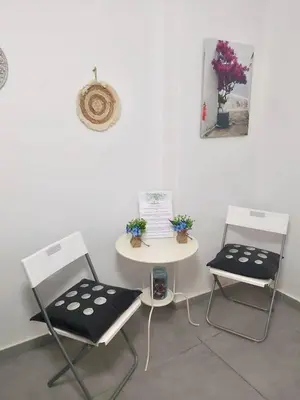 two chairs and a table in a room with a white wall at Cozy apartment in Athens center in Athens