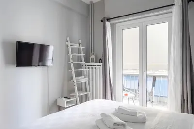 a white bedroom with a bed with towels on it at Stylish Central Cozy one BEDROOM Apartment in Athens