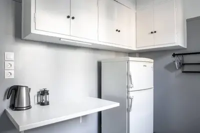 a kitchen with white cabinets and a refrigerator at Stylish Central Cozy one BEDROOM Apartment in Athens