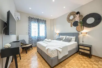 a bedroom with a bed and a desk and a television at Exclusive Mavili Suite by CloudKeys in Athens