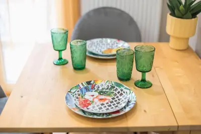a wooden table with plates and glasses on it at Exclusive Mavili Suite by CloudKeys in Athens