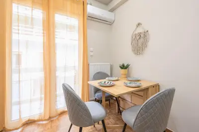 a dining room with a wooden table and chairs at Exclusive Mavili Suite by CloudKeys in Athens
