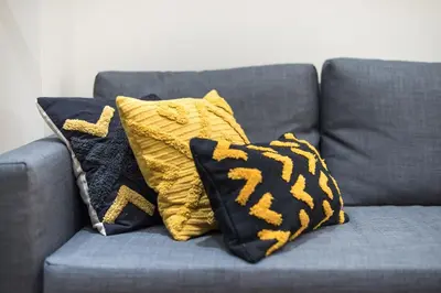 a gray couch with two pillows on it at Exclusive Mavili Suite by CloudKeys in Athens