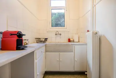 a white kitchen with a sink and a window at the Artistic One-Bedroom Studio in Plaka in Athens