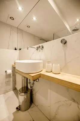 a white bathroom with a sink and a tub at the Artistic One-Bedroom Studio in Plaka in Athens