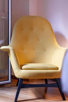 a yellow chair sitting in front of a window at the Artistic One-Bedroom Studio in Plaka in Athens