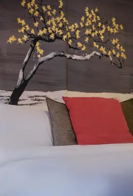 a bed with a red pillow and a tree on it at the Artistic One-Bedroom Studio in Plaka in Athens