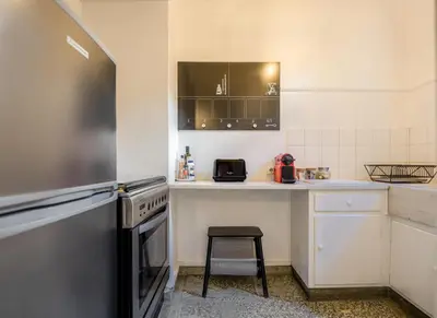 a small kitchen with a stove and a stool in it at the Artistic One-Bedroom Studio in Plaka in Athens