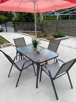a table with four chairs and a red umbrella at D & A house 150m from Chalandri metro station in Athens