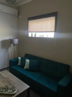 a living room with a blue couch and a window at D & A house 150m from Chalandri metro station in Athens