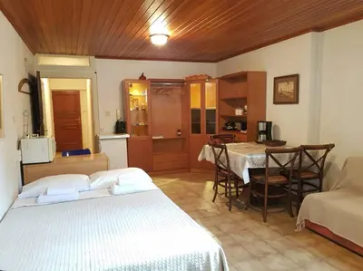 a bedroom with a bed and a kitchen with a table at Beautiful Studio at Glyfada in Athens