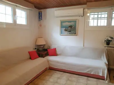 a living room with a white couch with red pillows at Beautiful Studio at Glyfada in Athens