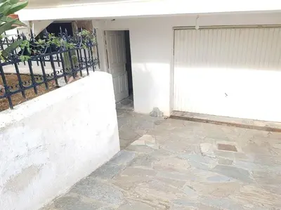 a white building with a gate and a stone patio at Beautiful Studio at Glyfada in Athens