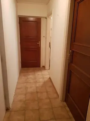 a hallway with a door and a tiled floor at Beautiful Studio at Glyfada in Athens