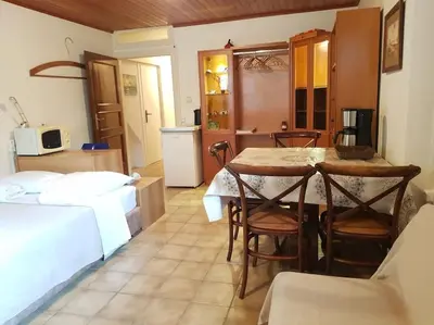 a room with a table and chairs and a kitchen at Beautiful Studio at Glyfada in Athens
