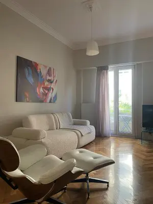 a living room with a couch and a chair at Quiet, central 2bd Apt, Kolonaki in Athens