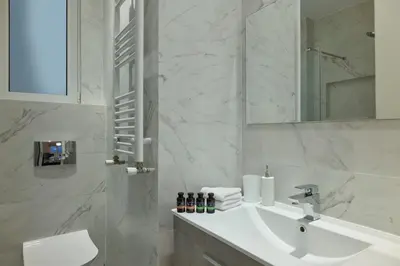 a white bathroom with a sink and a mirror at Quiet, central 2bd Apt, Kolonaki in Athens