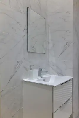 a white bathroom with a sink and a mirror at Quiet, central 2bd Apt, Kolonaki in Athens