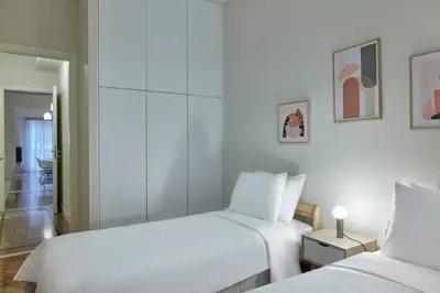 two beds in a room with white walls at Quiet, central 2bd Apt, Kolonaki in Athens