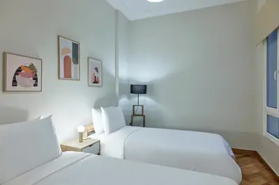 a white bedroom with two beds and a window at Quiet, central 2bd Apt, Kolonaki in Athens