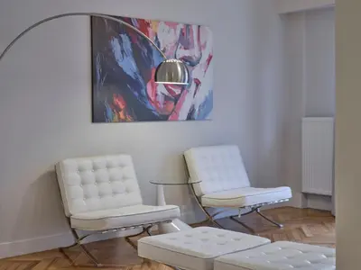 two chairs and a bench in a room with a painting at Quiet, central 2bd Apt, Kolonaki in Athens