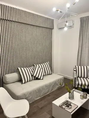 a living room with a couch and a table at Metropolitan Complex Apartment-next to Metropolitan Hospital,Karaiskaki,Sef in Piraeus