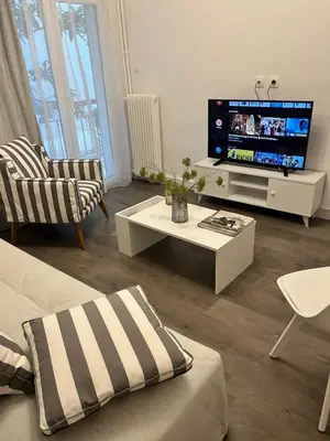 a living room with a tv and a couch and a table at Metropolitan Complex Apartment-next to Metropolitan Hospital,Karaiskaki,Sef in Piraeus