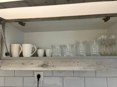 a shelf with cups and mugs on it at Metropolitan Complex Apartment-next to Metropolitan Hospital,Karaiskaki,Sef in Piraeus