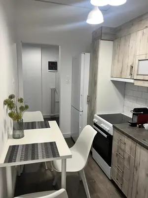 a kitchen with a table and chairs and a refrigerator at Metropolitan Complex Apartment-next to Metropolitan Hospital,Karaiskaki,Sef in Piraeus