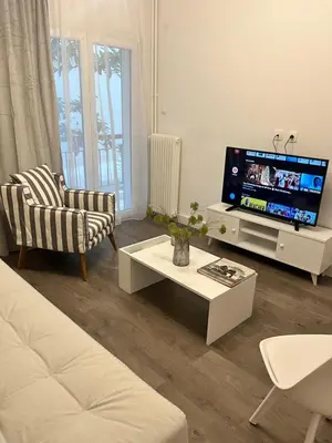 a living room with a couch and a tv at Metropolitan Complex Apartment-next to Metropolitan Hospital,Karaiskaki,Sef in Piraeus