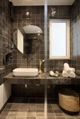 a black tiled bathroom with a sink and a mirror at Happiness Luxury Central Apartment in Athens