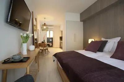 a bedroom with a bed and a desk with a television at Happiness Luxury Central Apartment in Athens