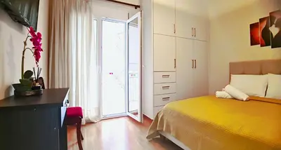 a bedroom with a yellow bed and a large window at Apartment in Athens, Kallithea in Athens