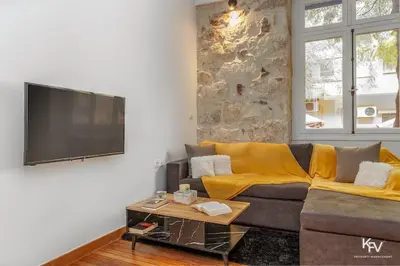 a living room with a couch and a flat screen tv at Modern and Cozy apartment in the heart of Athens in Athens