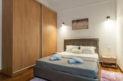 a bedroom with a bed with two blue pillows on it at Modern and Cozy apartment in the heart of Athens in Athens