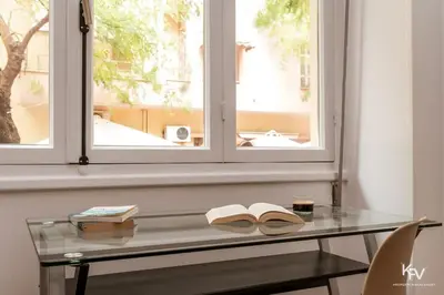 a glass table with two books on it next to a window at Modern and Cozy apartment in the heart of Athens in Athens